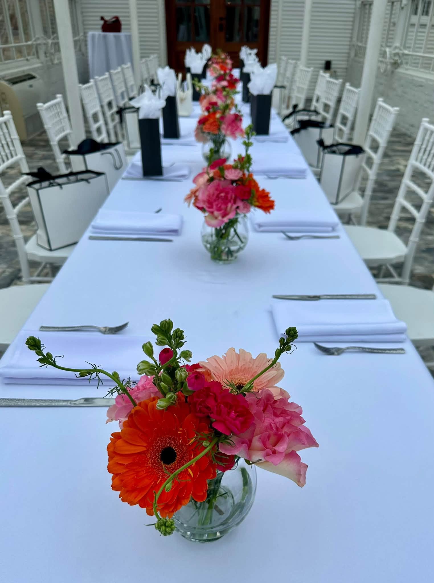 A long celebration table styled with colorful flowers